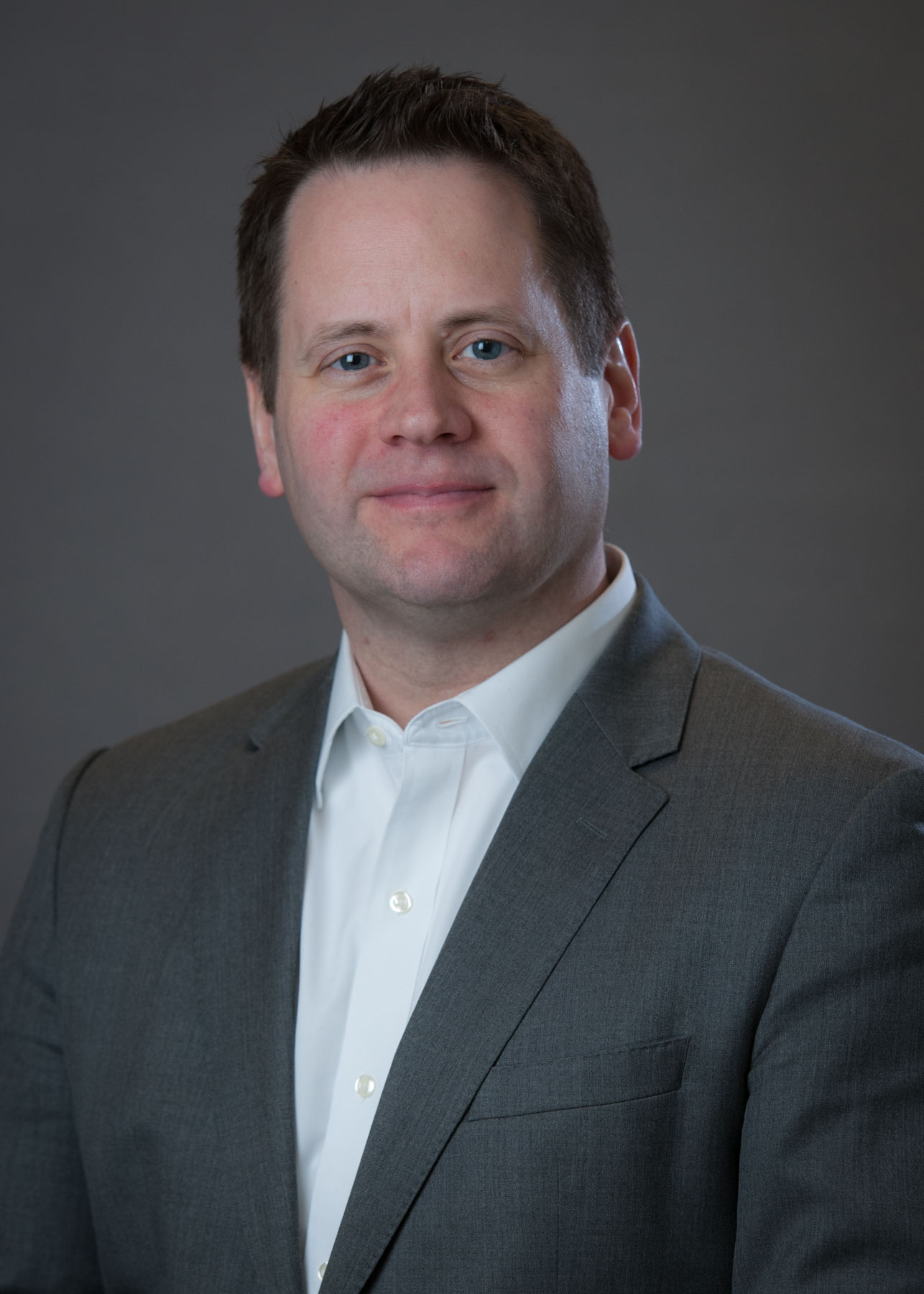 Matt Knell Photo of a man dressed in a gray suit with a smile on the face.