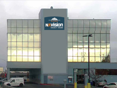Photo of the Financial Services Center's branch exterior in Anchorage, AK with a dark blue and orange logo reading Nuvision Credit Union Alaska complete with a mountain decal.