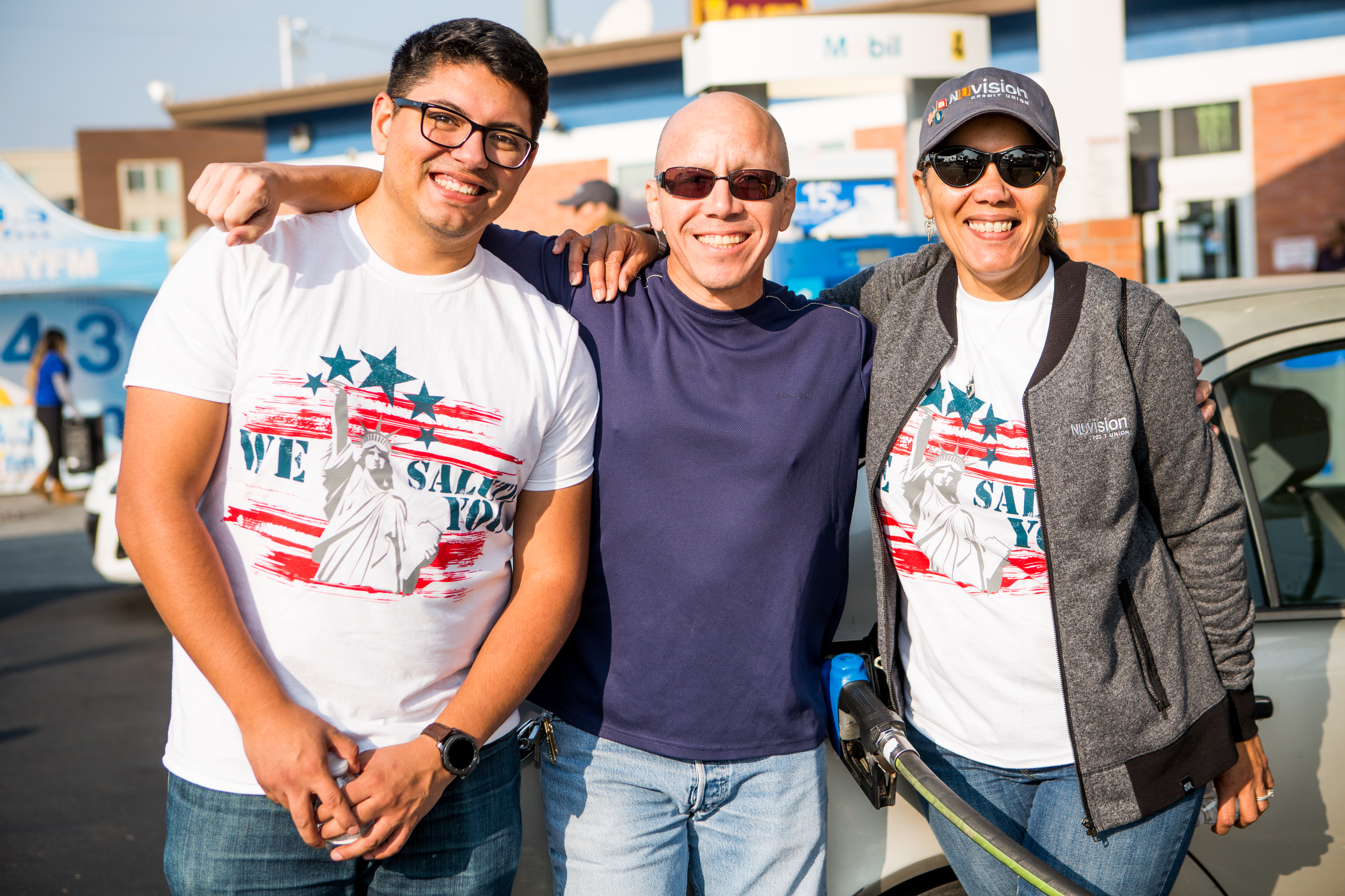 A group of four people wearing red, white and blue shirts with smiles on their faces.