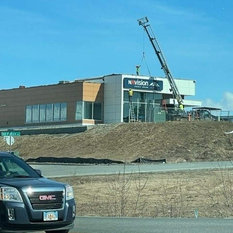 Nuvision Alaska Wasilla Branch exterior sitting on a dirt lot in the background. A black GMC truck is placed on the bottom left corner.